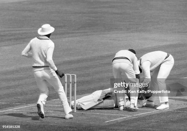 West Indies fielders Roger Harper, wicketkeeper Jeffrey Dujon and Desmond Haynes go to the aid of England batsman Andy Lloyd after he collapsed...