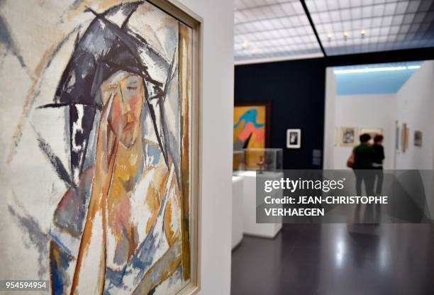 Visitor stand in background of pieces of art by the couple of artists Natalia Gontcharova and Mikhaïl Larionov during the exhibition "Couples...