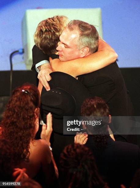 Country music superstar Garth Brooks gets a hug from his wife Sandy after receiving an award for favorite country album during the 27th Annual...