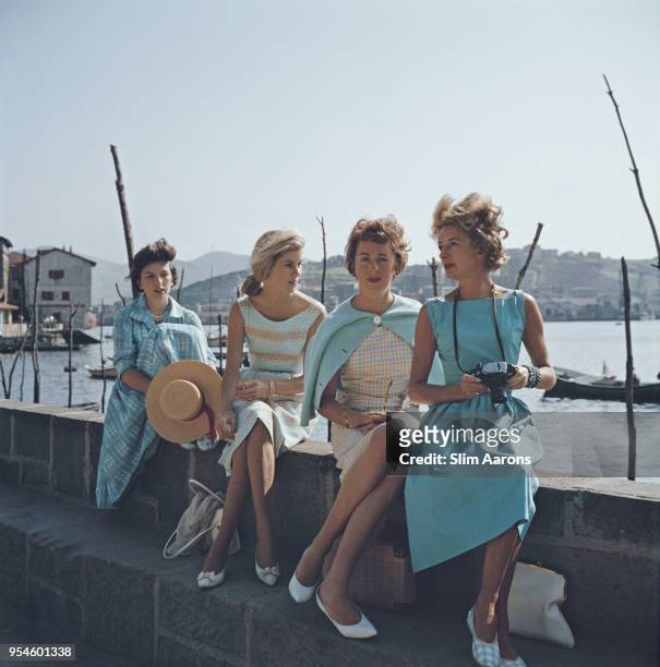 Heiress and socialite Nonie Phipps and friends sit on the waterfront in Biarritz, France, 1960.