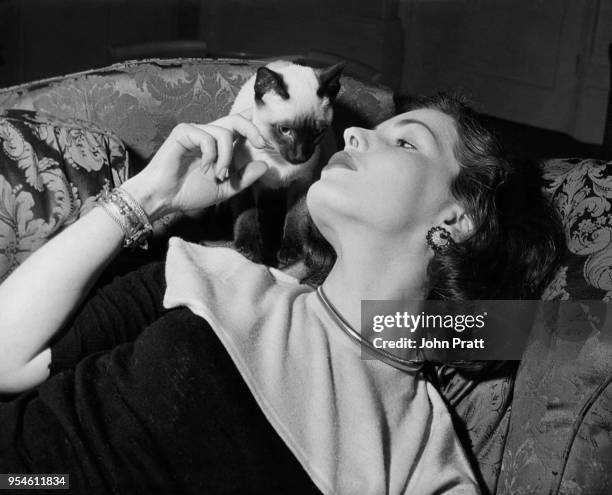 Scottish actress Elizabeth Sellars with her pet Siamese cat at her home in Bayswater, London, 1952.