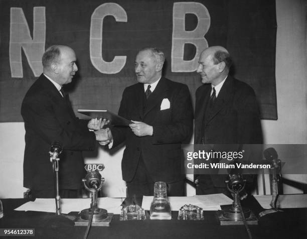 British Labour politician Emanuel 'Manny' Shinwell , the Minister of Fuel and Power, presents a copy of the Coal Mining Industry Nationalisation Act...