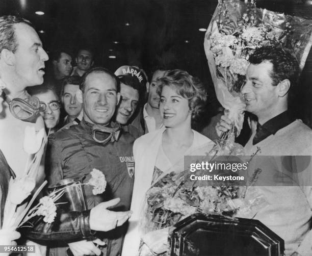 British racing driver Stirling Moss wins the midget car 'European Grand Prix' at the Palais des Sports in Paris, France, while Hermano da Silva Ramos...