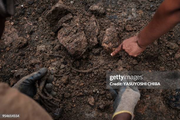 Picture taken on April 30 shows people collecting victims' bones from a pit which was used as mass grave during 1994 Rwandan genocide and hidden...