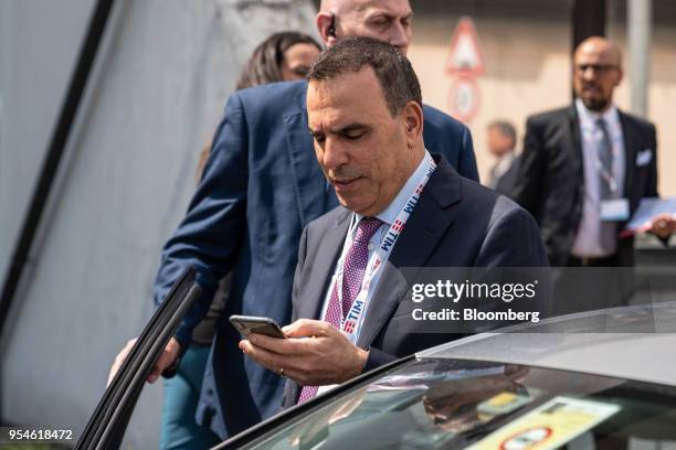 Amos Genish, chief executive officer of Telecom Italia SpA, uses his mobile phone as he leaves following an extraordinary shareholders' meeting at...