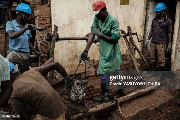 Picture taken on April 30 shows workers looking for victims' bones from a pit which was used as mass grave during 1994 Rwandan genocide and hidden...