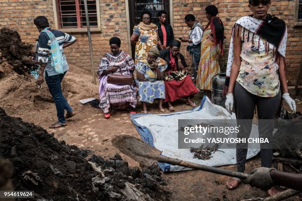 Picture taken on April 30 shows people collect victims' bones from a pit which was used as mass grave during 1994 Rwandan genocide and hidden under a...