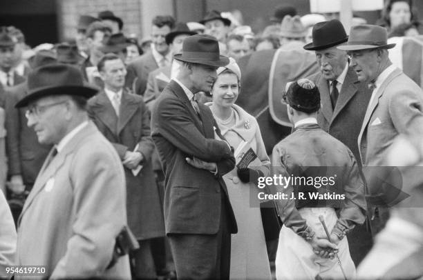 Queen Elizabeth II and Prince Philip chatting with jockey R Elliott, Charles Moore and Tom Mason at Newbury Racecourse, UK, 27th May 1961.