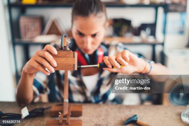 artigiana che rifinisse lampada di legno fatta a mano in officina. concetto fai-da-ti - cacciavite foto e immagini stock