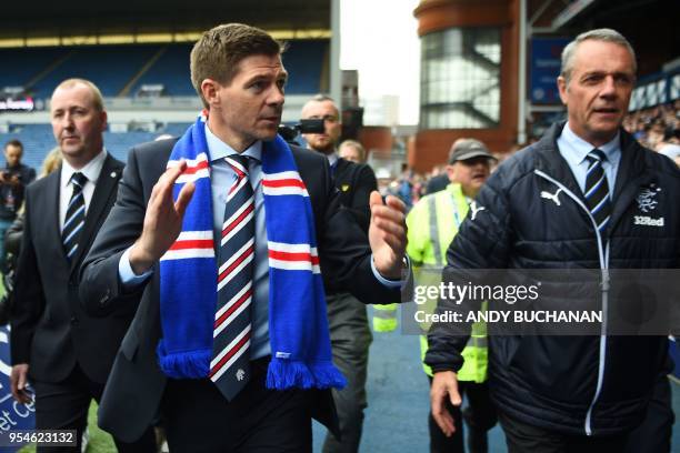 Former England and Liverpool captain Steven Gerrard gestures as he is introduced to supporters inside Ibrox stadium after being unveiled as Rangers'...