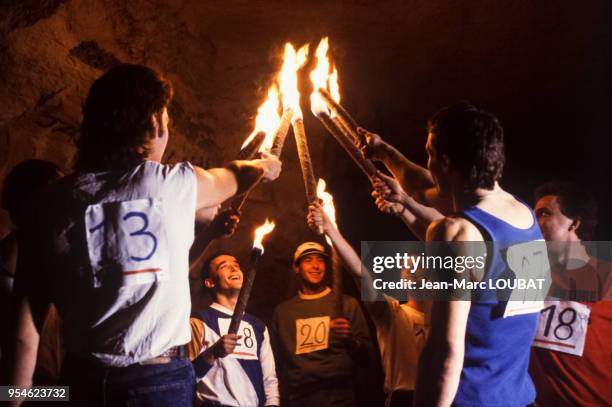 Concurrents du marathon des Catacombes de Paris avec leur torche en mars 1985, France.
