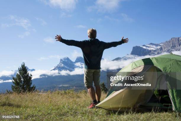 hombre disfruta de acampar en una pradera de montaña - bow valley fotografías e imágenes de stock