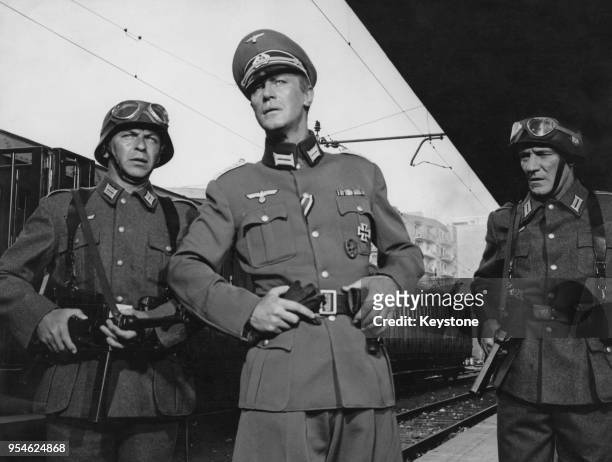 From left to right, American singer and actor Frank Sinatra , Irish actor Edward Mulhare and English actor Trevor Howard dressed as German soldiers...