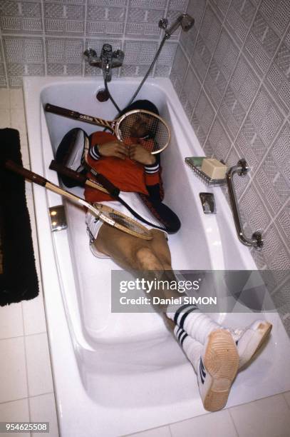 Le champion de tennis Ilie Nastase dans sa baignoire avec ses raquettes, circa 1980, France.