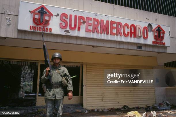 Soldat montant la garde devant un supermarché pendant les émeutes provoquées par l'entrée en vigueur du plan d'austérité en mars 1989, à Caracas,...