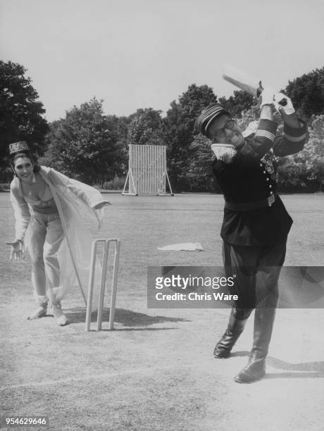 American actor Phil Silvers and English actress Anita Harris filming a cricket scene for the Carry On film 'Follow That Camel' at Pinewood Studios,...