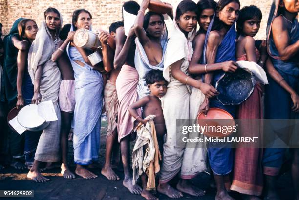 Femmes et enafants faisant la queue pour recevoir de la nourriture lors d'une famine à Dacca, en novembre 1974, Bangladesh.
