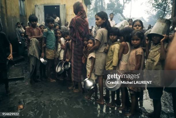Femmes et enafants faisant la queue pour recevoir de la nourriture lors d'une famine à Dacca, en novembre 1974, Bangladesh.