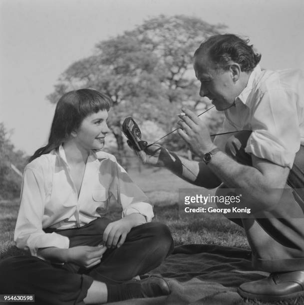 British cinematographer Geoffrey Unsworth checks actress Jean Simmons with a handheld light meter on the set of the film 'The Clouded Yellow' at a...