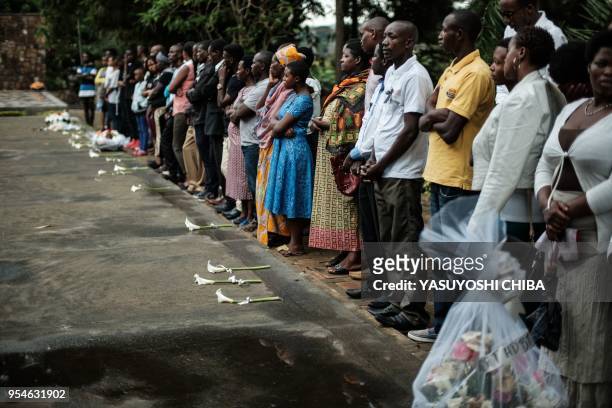 Picture taken on April 29, 2018 shows people praying in front of the mass grave at the Kigali Genocide Memorial in Kigali, Rwanda. - According to the...