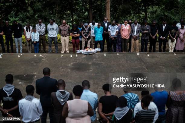 Picture taken on April 29, 2018 shows people praying in front of the mass grave at the Kigali Genocide Memorial in Kigali, Rwanda. - According to the...