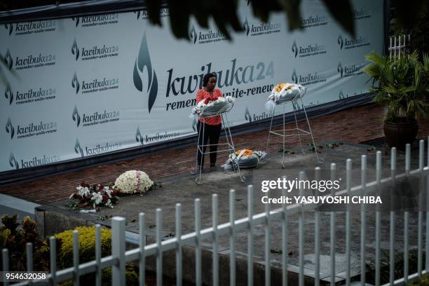 Picture taken on April 29, 2018 shows a woman praying in front of the mass grave at the Kigali Genocide Memorial in Kigali, Rwanda. - According to...