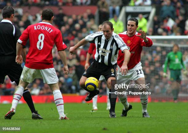 Alan Shearer of Newcastle United in action against Wayne Rooney and John O'Shea of Manchester United during the Barclays Premiership match between...