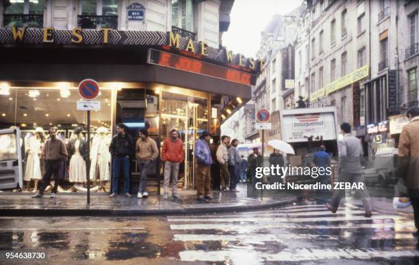 Travailleurs clandestins sur un trottoir en décembre 1990 à Paris, France.