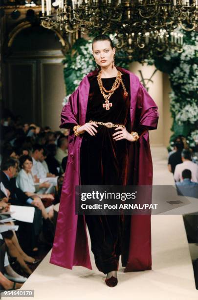 Shalom Harlow en robe de velours rouge et étole de soie rose défile pour la collection Saint Laurent Haute Couture Automne-Hiver 97/98, le 9 juillet...