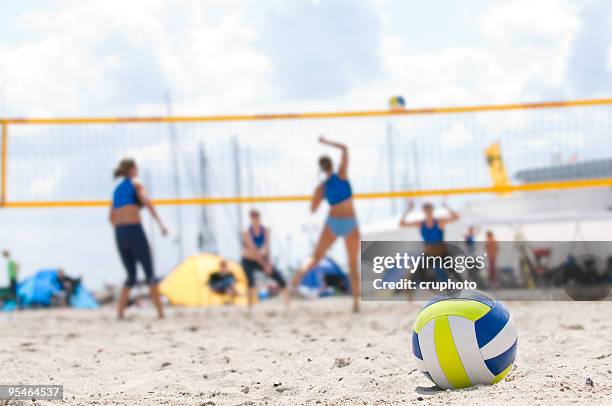 beach volleyball with closeup of ball in foreground - beachvolleyball stock pictures, royalty-free photos & images