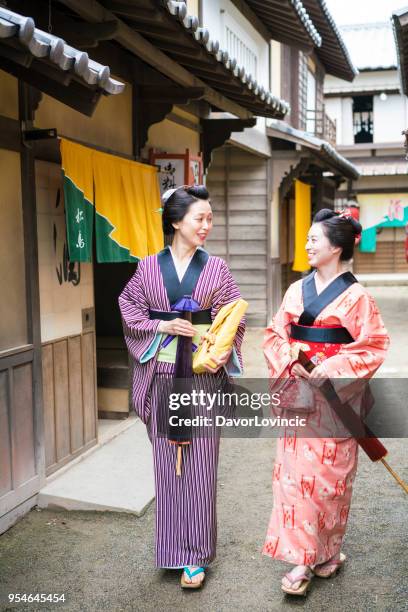 zoals in oude tijden, vrouw lopend en pratend op een oude straat in japan - lypsekyo16 stockfoto's en -beelden