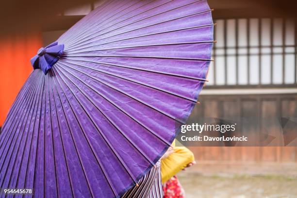 vrouwen onder de blauwe paraplu's op een oude straat in kyoto, japan - lypsekyo16 stockfoto's en -beelden