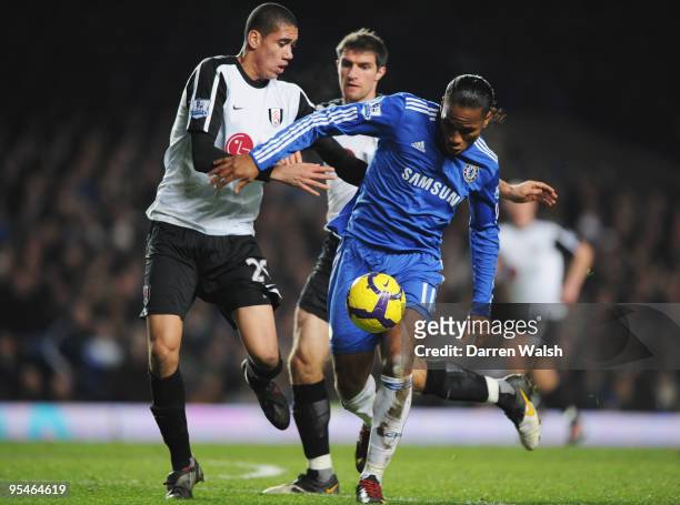 Didier Drogba of Chelsea takes on Chris Smalling and Aaron Hughes of Fulham during the Barclays Premier League match between Chelsea and Fulham at...