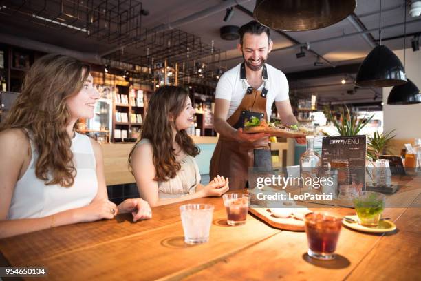 clientes de un barista en un café moderno - servir comida y bebida fotografías e imágenes de stock