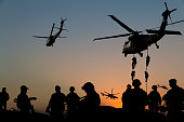 Silhouettes of soldiers on Military Mission at dusk