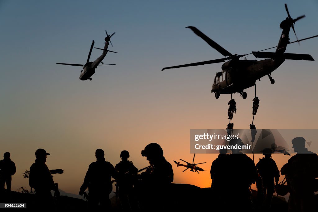Silhouettes of soldiers on Military Mission at dusk