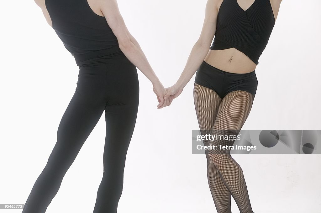 A man and woman from the neck down wearing black dance tights