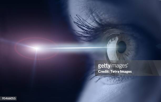 close-up of an eye with a light beam shining into it - hoornvlies stockfoto's en -beelden