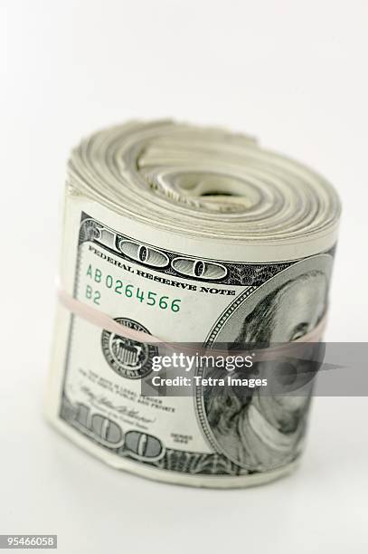 a roll of hundred dollar bills - money roll foto e immagini stock