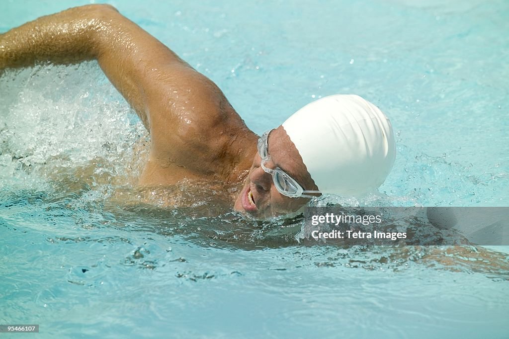 A man swimming with a swimming cap and goggles