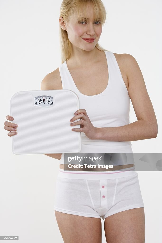 A woman holding up a scale