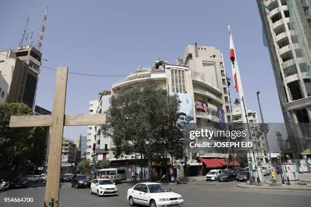 Wooden cross is fixed in a main square in Beirut's Christian neighbourhood of Achrafieh on May 4 in front of a huge portrait of Lebanon's...