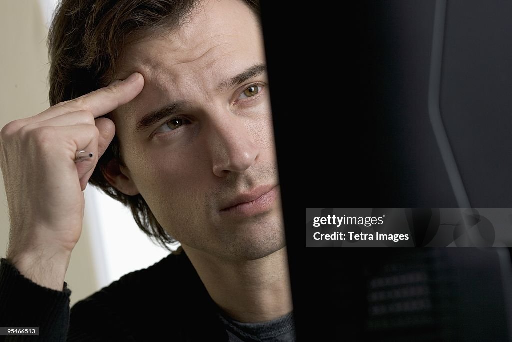 A man looking confused in front of his desktop computer