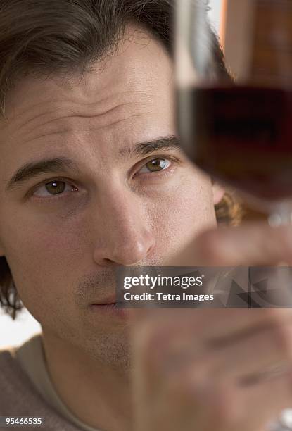 a man holding up a glass of red wine - esperto foto e immagini stock