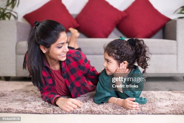 mom with daughter relaxing on carpet at home - mother and girl stock pictures, royalty-free photos & images