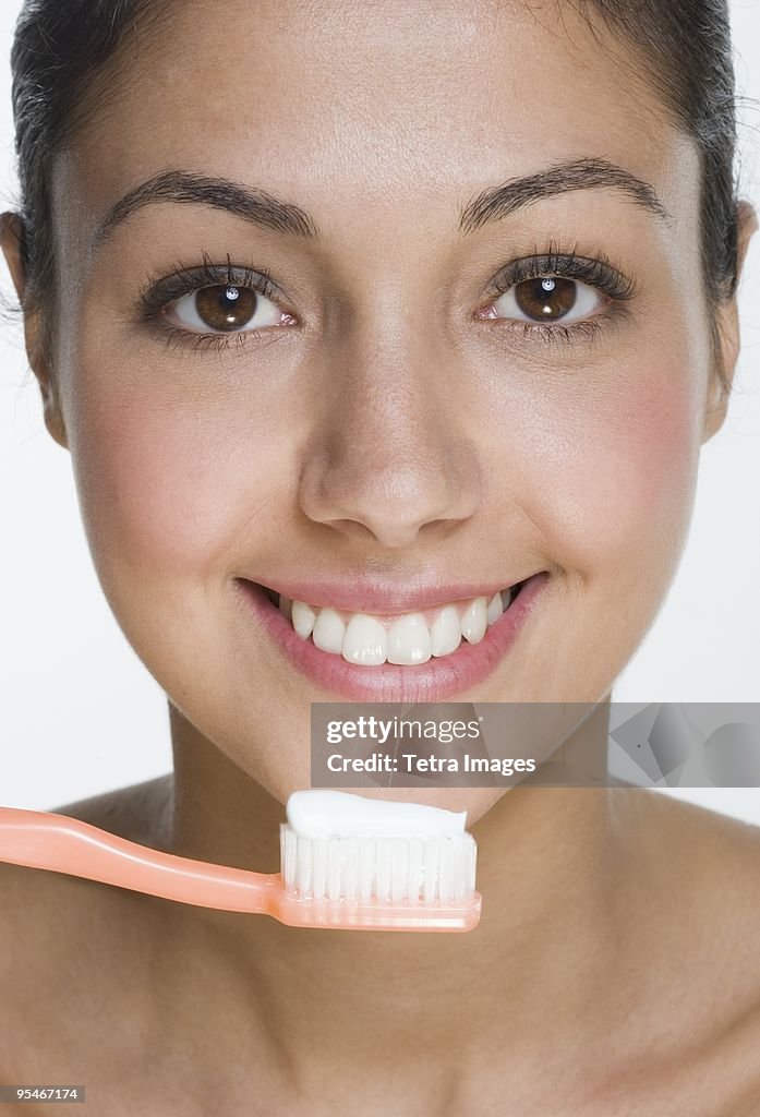 Woman smiling and holding toothbrush