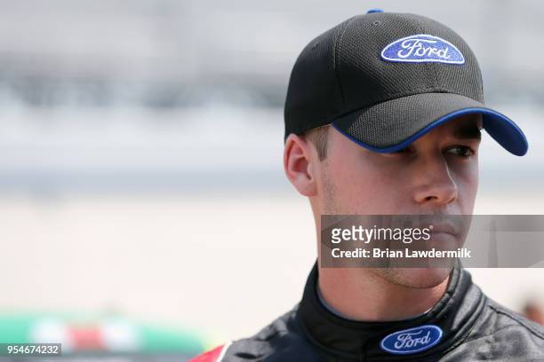 Ben Rhodes, driver of the Alpha Energy Solutions Ford, stands by his truck during qualifying for the NASCAR Camping World Truck Series JEGS 200 at...