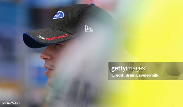 Ben Rhodes, driver of the Alpha Energy Solutions Ford, stands by his truck during qualifying for the NASCAR Camping World Truck Series JEGS 200 at...