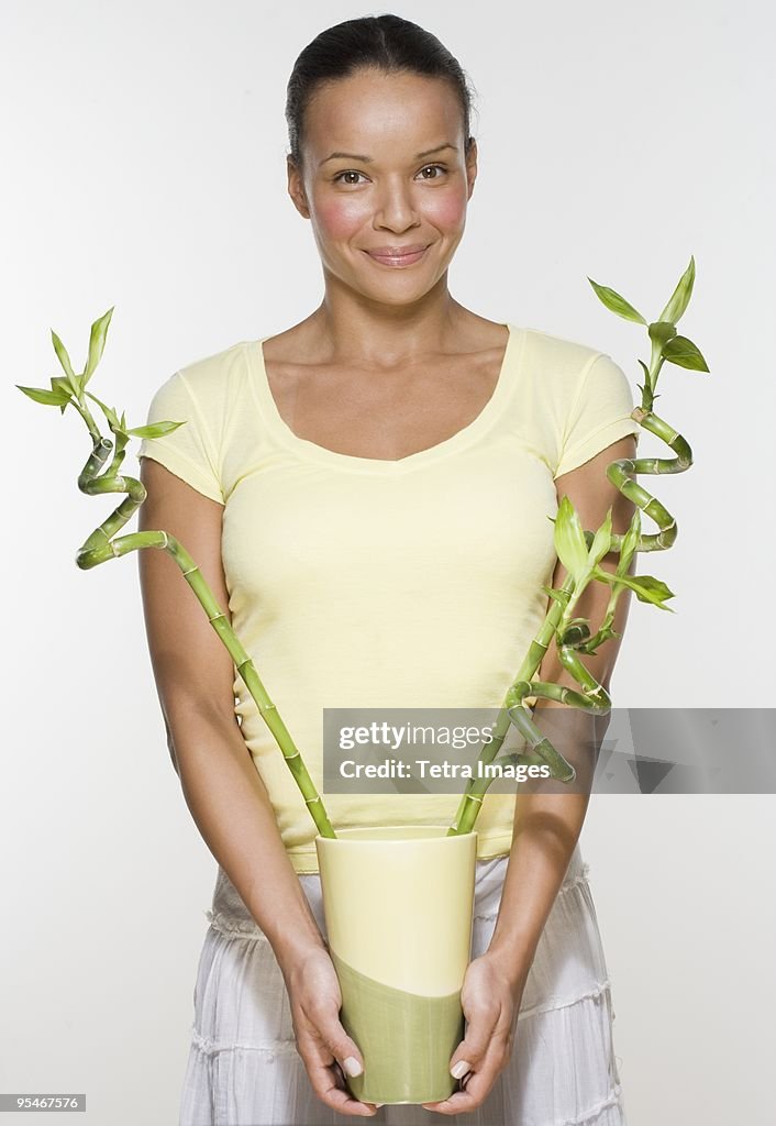 Woman holding bamboo stalks in a vase