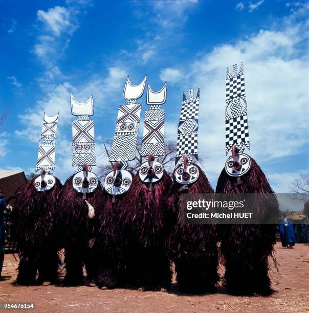 Masques Doyo des Bwa-Kademba lors d'un rite de procession, circa 1950, Burkina-Faso. Les danseurs tiennent le masque à la main au niveau du visage et...